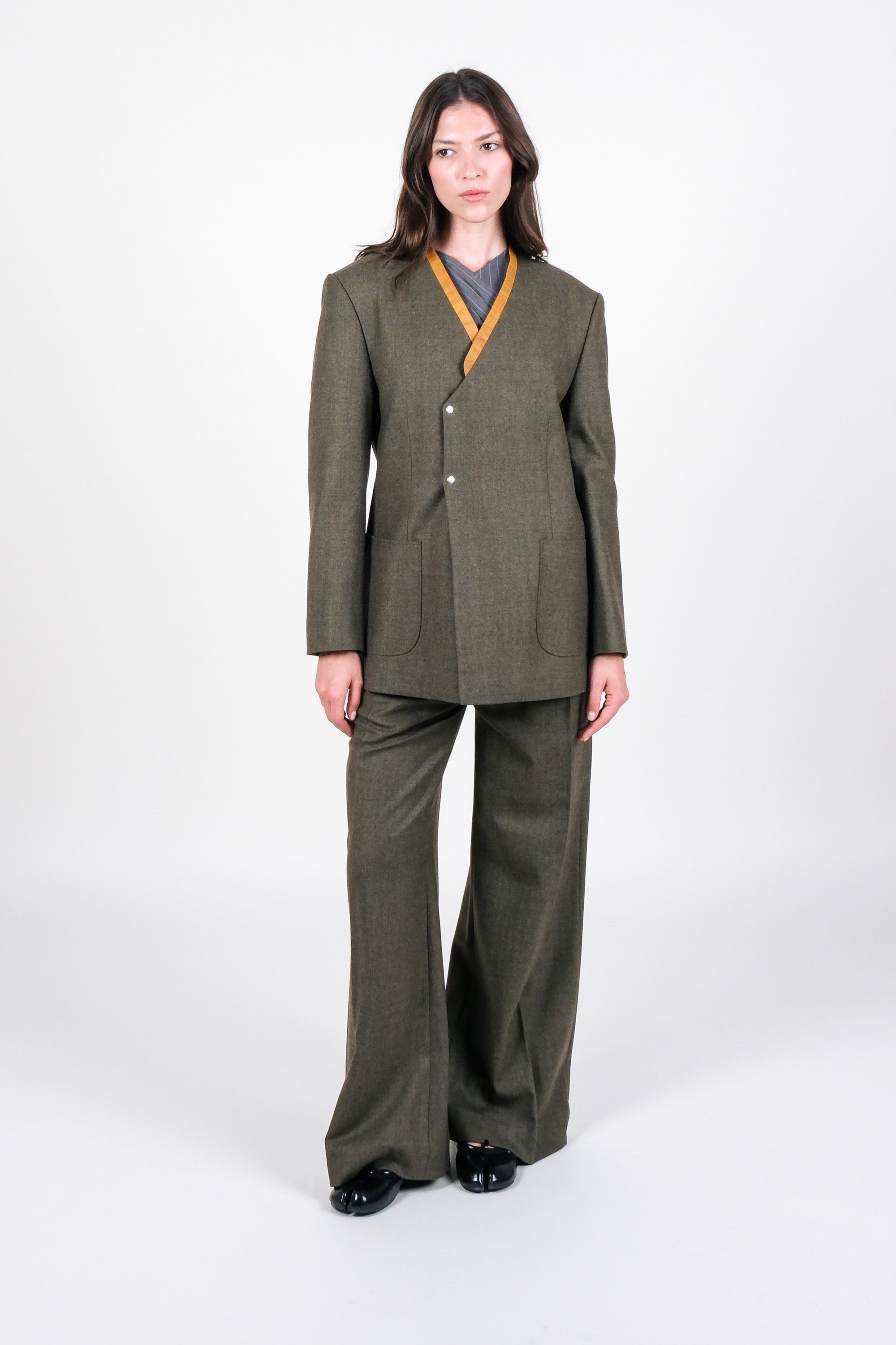 Woman wearing a green suit with a white background